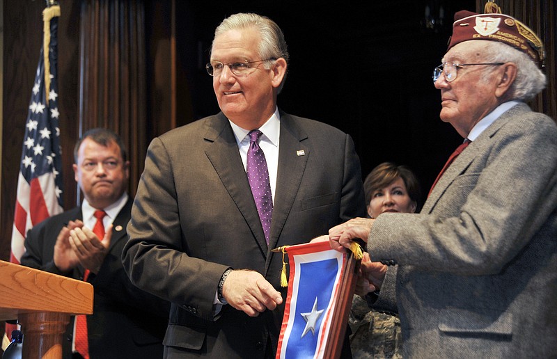 Gov. Jay Nixon, center, presents Wilburn Rowden with a Silver Star Banner on Monday. Rowden, a radio operator during World War II, was injured on his sixth mission and was held as a prisoner-of-war for more than a year. 
