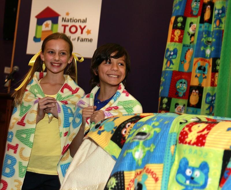 Maddie Berl of Victor and Chase Boss of Pittsford help induct the blanket into the National Toy Hall of Fame on Thursday in Rochester, N.Y.  The blanket, along with Hot Wheels and the dollhouse, landed in the National Toy Hall of Fame.