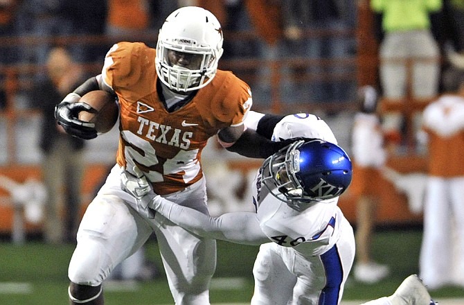 Texas running back Joe Bergeron tries to escape the grasp of Kansas safety Joe Mitchell in a game Oct. 29 in Austin, Texas.