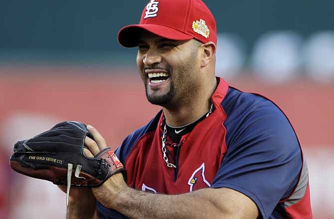 In this Oct. 23, 2011 file photo, St. Louis Cardinals' Albert Pujols prepares for Game 4 of baseball's World Series, against the Texas Rangers, in Arlington, Texas. Pujols' first free-agent tour is off to a surprising start: The three-time NL MVP visited the Florida Marlins, Friday Nov. 11, 2011.