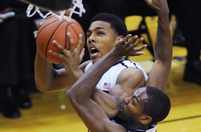 Missouri's Phil Pressey (in white) gets fouled by Mercer's Langston Hall on a drive to the basket during the first half of Monday night's game in Columbia.