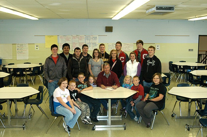 City of California Mayor Norris Gerhart signs a Resolution proclaiming National Education Week.  Present for the occasion at the California Elementary School are students from each elementary grade, seated, and high school A+ students, standing. National Education Week is Nov. 13 - 19.