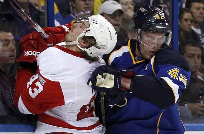 St. Louis Blues' David Backes, right, checks Detroit Red Wings' Darren Helm into the boards during the third period of an NHL hockey game Tuesday, Nov. 15, 2011, in St. Louis. The Blues won 2-1.