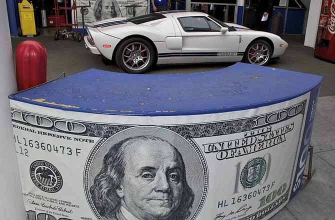 This Nov. 10, 2011 photo shows a banner offering hundred dollar cash incentives next to a Ford GT sports car at the Galpin Motors of North Hills car dealership, the largest Ford retailer in the U.S., in Los Angeles.
