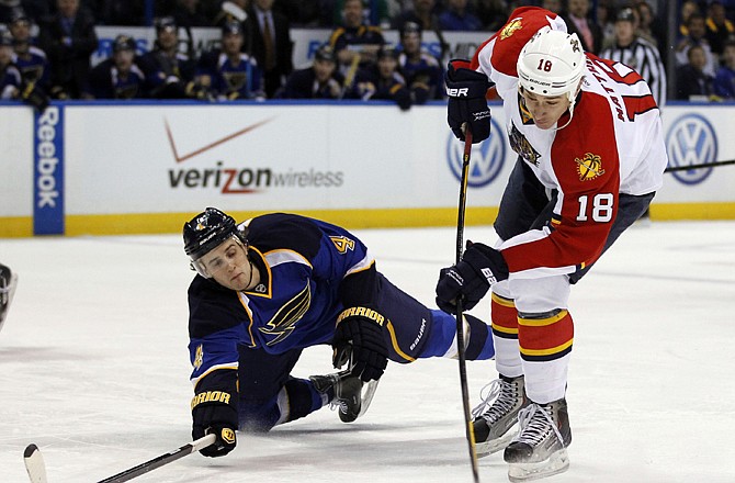 Shawn Matthias of the Panthers takes a shot as Kris Russell of the Blues defends during the first period of Thursday's game in St. Louis.