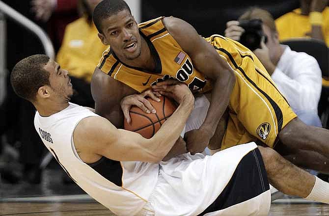 California guard Justin Cobbs, bottom, and Missouri guard Kim English (24) hit the floor as they scramble for the ball during the first half of an NCAA college basketball game Tuesday, Nov. 22, 2011, in Kansas City, Mo.