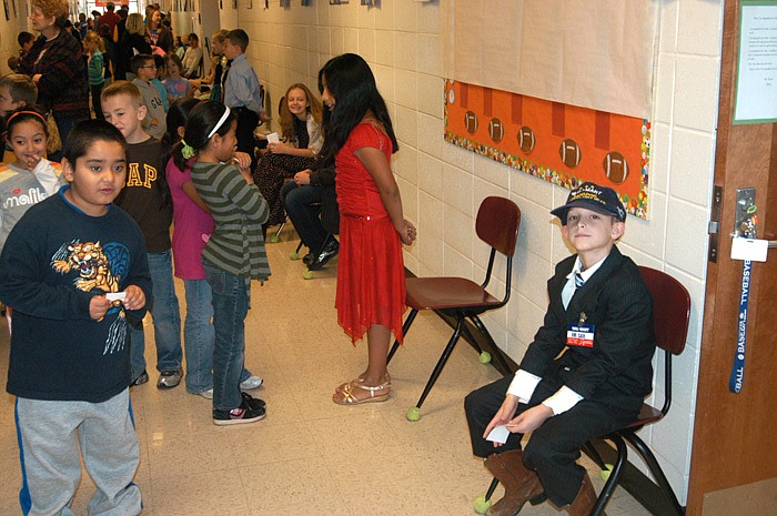 The "Famous Missourians Walk of Fame" by fourth graders at the California Elementary School on Friday, Nov. 18, draws a number of students from other classes. Kansas City journalist and Civil Rights advocate Lucille Bluford, center of photo, tells her story, as Sam Walton, founder of Wal-Mart, right, waits for an audience.