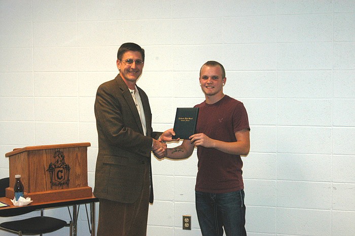 California R-I School Board President Steven Burger presents a high school diploma to Tyler Walker. Walker completed the requirements through the Missouri Options Program. The new grad presented a short video to the board titled "How My Diploma Will Help Me in the Future." Several friends and relatives attended the presentation, including his cousin. The cousin, who drove in from Virginia, recently completed Navy Seal training.