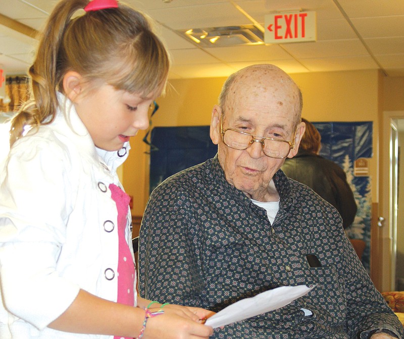 Fourth-grader Terris Parsons, 9, reads a Thanksgiving poem to Charles Lawrence, resident at Fulton Presbyterian Manor. Fourth-grade classes from Bush Elementary School visited the manor Friday to bring the residents Thanksgiving placemats and poems.