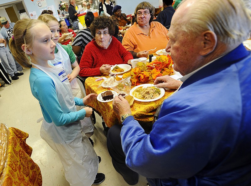 Volunteers Anna Schnieders, left, and Arabella Apperson deliver desserts to guests attending Thursday's Thanksgiving dinner at the Jefferson City Salvation Army.