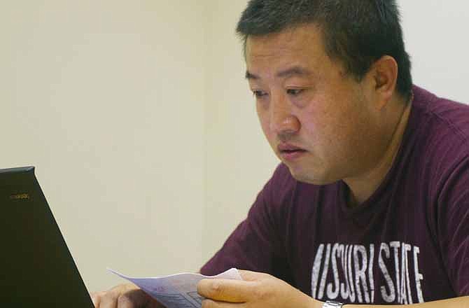 In this June 28, 2011 photo, Wang Chengdong, a Chinese student in the Executive MBA program, works in a library study room at Missouri State University in Springfield, Mo. (AP Photo/The News-Leader, Bob Linder)