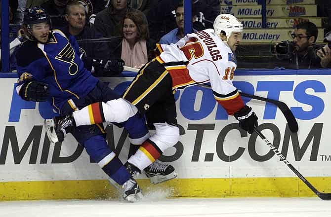 St. Louis Blues' Matt D'Agostini (36) collides with Calgary Flames' Tom Kostopoulos (16) in the second period of an NHL hockey game on Friday, Nov. 25, 2011, in St. Louis.