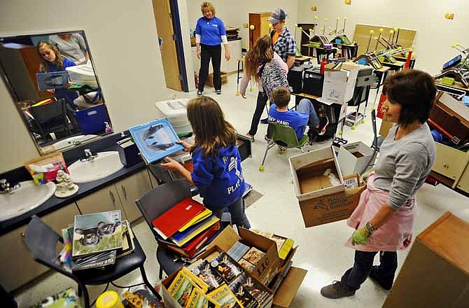 Sixth grader Amanda Braun, front left, and her mother Shannon Braun, right, sort through books and other items after helping move classroom materials into Leann Bonnett's new 5th- and 6th-grade classroom at Immanuel Lutheran School in Honey Creek, Mo.