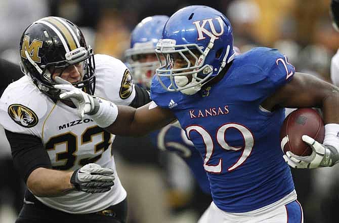 Kansas running back James Sims (29) rushes past Missouri linebacker Luke Lambert (33) during the first half of an NCAA college football game at Arrowhead Stadium in Kansas City, Mo., Saturday, Nov. 26, 2011.