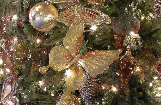 Christmas trees featuring traditional decorations and neutral colors are on display at Petals for You.

