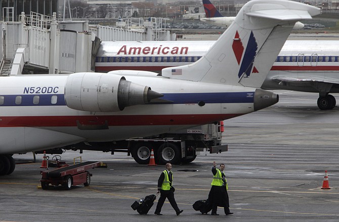 American Airlines planes are parked at a gate Tuesday at LaGuardia Airport in New York. The company says it will continue to operate flights, honor tickets and take reservations.