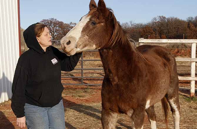 Cheri White Owl, founder of Horse Feathers Equine Rescue, is pictured with one of the 33 horses she is currently caring for in Guthrie, Okla., Tuesday, Nov. 29, 2011. Slaughterhouses could be ready to kill horses within a month if the U.S. Department of Agriculture provides funding for meat inspectors, days after Congress quietly opened the door to the practice by lifting a 5-year-old ban on spending federal money on such inspections.