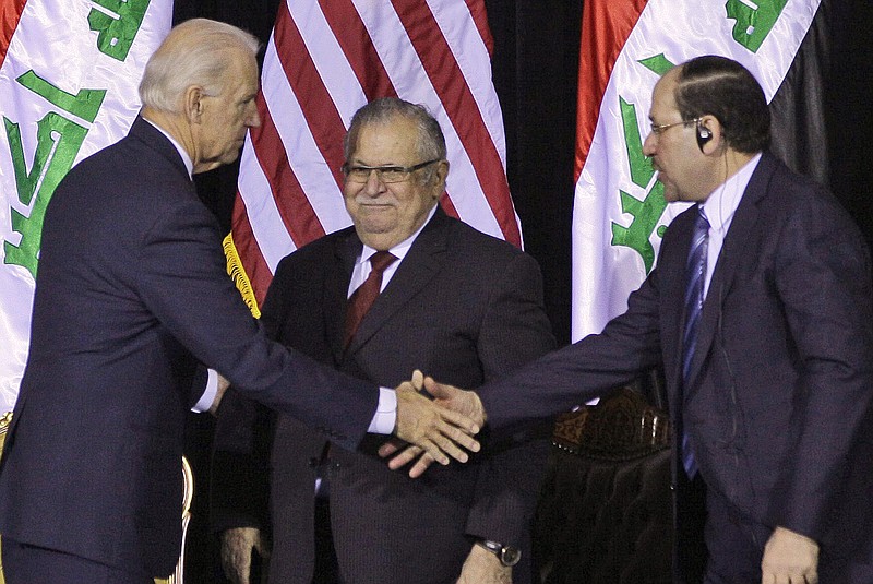 Iraqi Prime Minister Nouri al-Maliki, right, shakes hands with U.S. Vice President Joe Biden, left, as Iraqi President Jalal Talabani, center, looks on during a special ceremony at Camp Victory, one of the last American bases in Iraq.