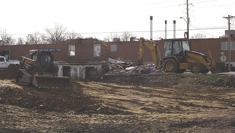 Equipment from Barry Maupin Excavating demolishes a lot on the corner of Bluff and Grand streets Thursday. According to Omar Kempker with Barry Maupin, the lot is being cleared to build a QuikStop convenience store.