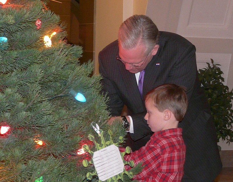 Children from Lawson Elementary School helped Gov. Jay Nixon and first lady Georganne Nixon trim a Christmas tree Friday at the Capitol. Afterward, Nixon spoke on several topics.