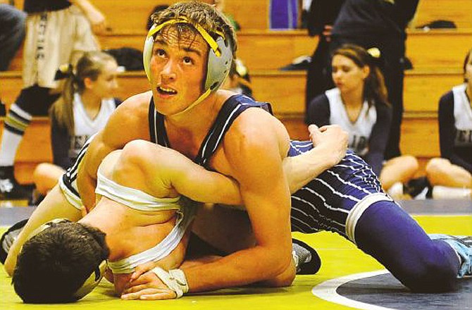 Helias junior Logan Shea glances at the clock Saturday while attempting to pin his Farmington opponent during the Helias Kickoff Classic at Rackers Fieldhouse.
