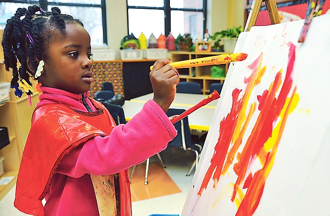 Khloe Johnson, 4, shows a visitor how students in her Title I preschool class use paint and a easel Monday morning at the Southwest Early Learning Center. The center received a donation from Rotary West for science supplies. To make science fun, the kids are learning how to mix primary colors such as red and yellow to make a new color, in this case, orange.