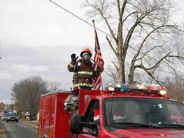 A fireman from the Jamestown Rural Fire Protection District holds an American flag during the Jamestown Christmas Parade held Dec. 3.