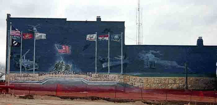 The military-themed mural covers the entire east side of the Post home of VFW Post 4345 in California.