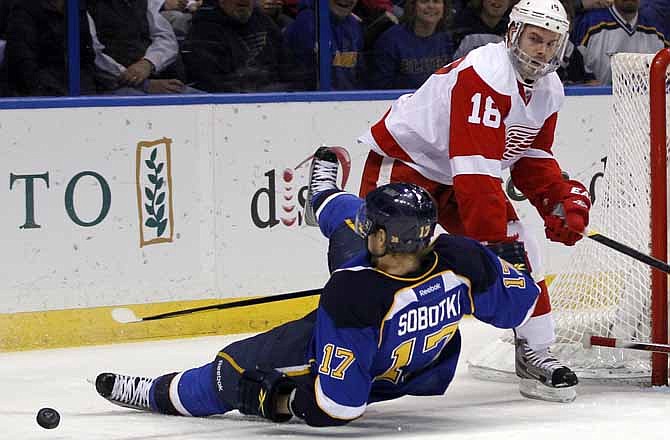 St. Louis Blues' Vladimir Sobotka, of the Czech Republic, slips as he chases a loose puck along side Detroit Red Wings' Ian White, right, during the second period of an NHL hockey game, Tuesday, Dec. 6, 2011, in St. Louis. 