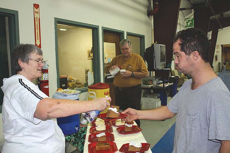 Sheral Johnson, housekeeper at Fulton United Church of Christ, adds whipped cream to Rob Aarestad's dessert Thursday at the annual Christmas meal UCC serves for Kingdom Projects, Inc. workers.