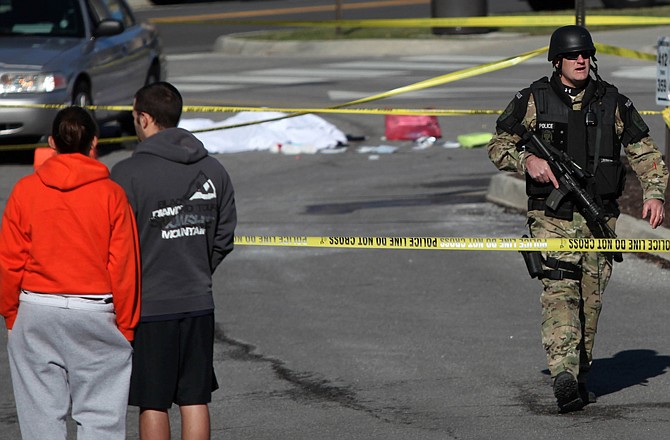 A police officer secures the scene where a gunman killed a police officer during a traffic stop Thursday on the campus of Virginia Tech in Blacksburg, Va. The gunman later was found dead.