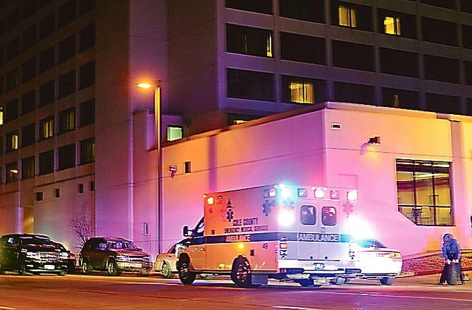 An ambulance waits outside the Capitol Plaza as a Highway Patrolman begins setting up for a crime scene investigation after Saturday night's shooting.