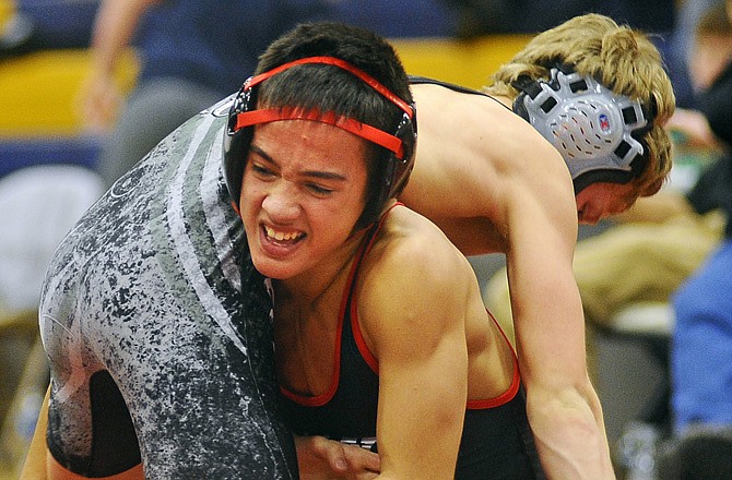 Corbin Howard of Jefferson City gets a grip on Robert King of Rock Bridge during their 106-pound match Saturday in the Missouri Duals.