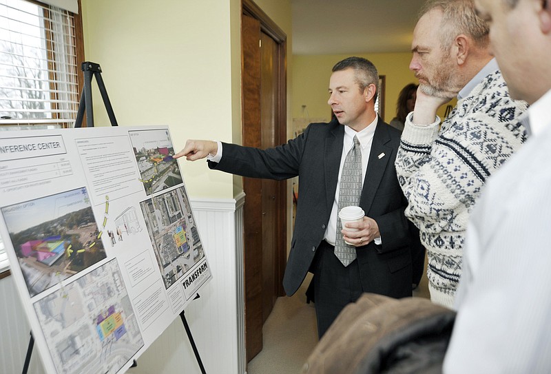 Steve Houser explains aspects of a proposed conference center to Jefferson City School Board member Dennis Nickelson, second right, and Trey Propes, of Candlewood Suites, during an open house Tuesday to mark the beginning of a campaign to convince city voters to approve a half-cent sales tax. 