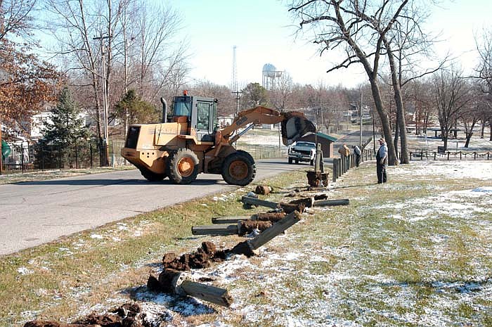 Employees of the City Park Department work on removing the posts and chain along Parkway Drive on Wednesday, Dec. 7. 