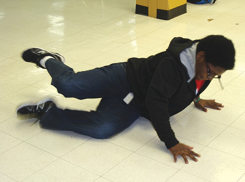 Nicholas Davis break dances on Nov. 17 in the Fulton High School cafeteria to demonstrate some of his techniques.