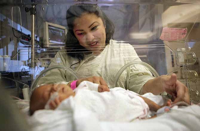 Haydee Ibarra looks at her 14-week-old daughter, Melinda Star Guido, at the Los Angeles County-USC Medical Center in Los Angeles, Wednesday, Dec. 14, 2011. At birth, Melinda Star Guido tipped the scales at only 9 1/2 ounces, a tad less than the weight of two iPhone 4S. Most babies her size don't survive, but doctors are preparing to send her home as soon as the end of the month. 