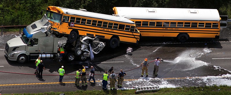 A crumpled pickup truck is seen between two St. James School District buses and a tractor-trailer in August 2010 on Interstate 44 near Gray Summit. Citing the wreck, in which investigators say the 19-year-old pickup driver was texting, federal transportation leaders this week pressed states to ban cellphone use by drivers.