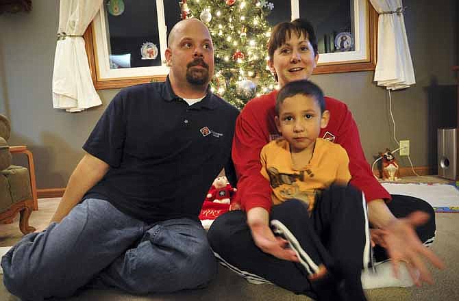 Dona, Matt, left, and Bryce Bremser, sit for photos at their Omaha, Neb. home Thursday Dec 15, 2011. The Bremsers had their layaway at Kmart paid off by an unknown good Samaritan.