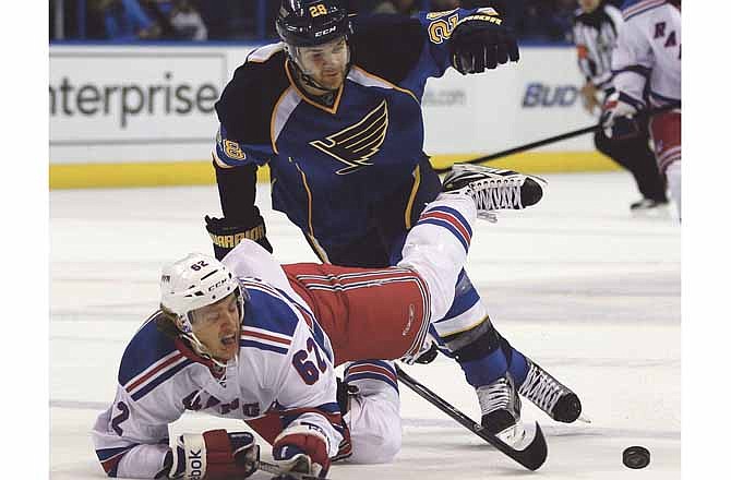 New York Rangers' Carl Hagelin, of Sweden, falls after colliding with St. Louis Blues' Carlo Colaiacovo, top, during the first period of an NHL hockey game Thursday, Dec. 15, 2011, in St. Louis.