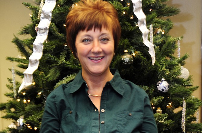 Wendy Waters stands in front of a Christmas tree in the lobby of Ameren Missouri on Madison Street.