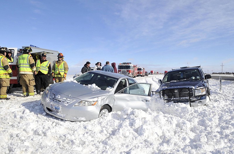 Emergency responders assist victims of a multiple-vehicle accident Tuesday on westbound Interstate 40 about 15 miles west of Amarillo, Texas. Travelers in the Texas Panhandle were urged to stay off ice-packed roads Tuesday after up to 10 inches of snow covered parts of the region. 