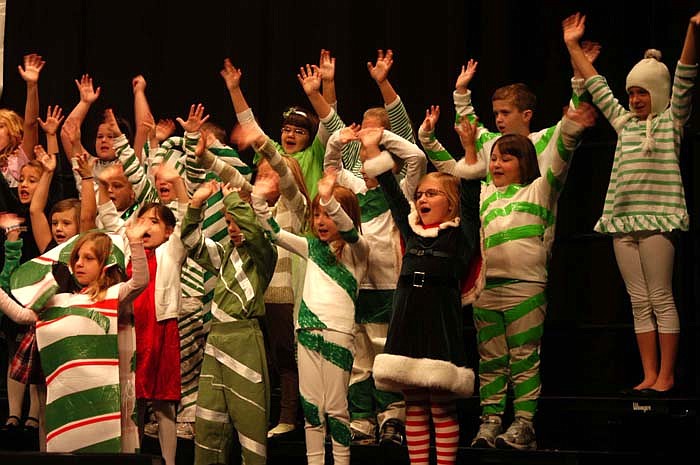 At the first grade Christmas program, the green candy canes sing. Mrs. Claus is at right front.