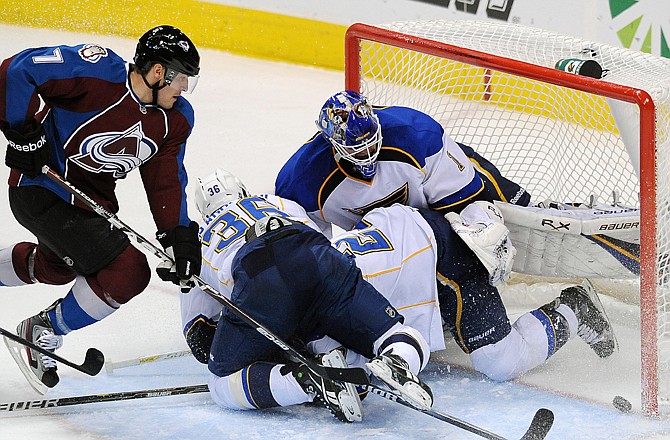 David Van Der Gulik of the Avalanche rushes the net as a trio of Blues try to stop the puck during Wednesday night's game in Denver.