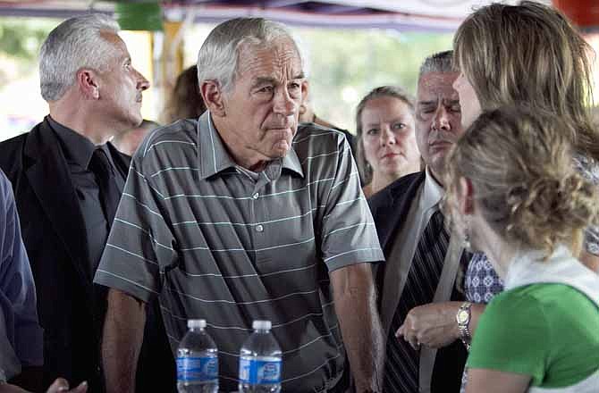 In this Aug. 27, 2011, file photo Republican presidential candidate, Rep. Ron Paul, R-Texas, listens to a supporter at the Polk County GOP summer picnic event held at the Iowa State Fairgrounds in Des Moines, Iowa. 