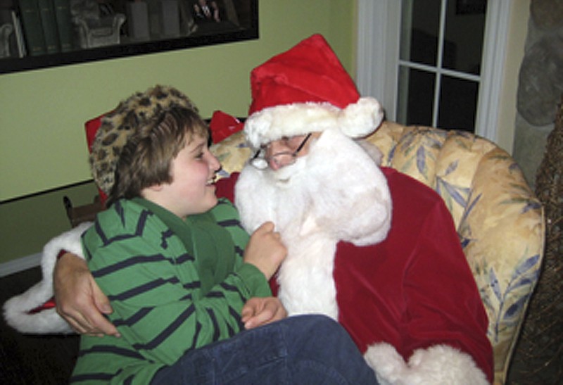 Ben Borre, 10, of West Hartford, Conn., sits with an autism-friendly Santa Claus, Ray Lepak, on Dec. 11, who is also Ben's grandfather.