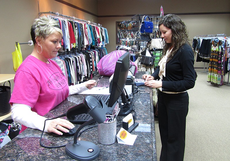 Nikki Payne, owner of The Snob Shop Exchange, rings up a purchase by Taos resident Kelsey Sandbothe on Tuesday. The new downtown business pays cash for top-name women's clothing and resells the items.