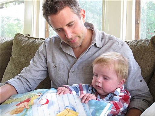 In this Sept. 14, 2011 photo, Matt Hammitt reads a book to his 1-year-old son, Bowen, at their home in Perrysburg, Ohio. Hammitt, lead singer for the Christian rock band Sanctus Real, has released an album inspired by his son who was born with a rare heart defect.