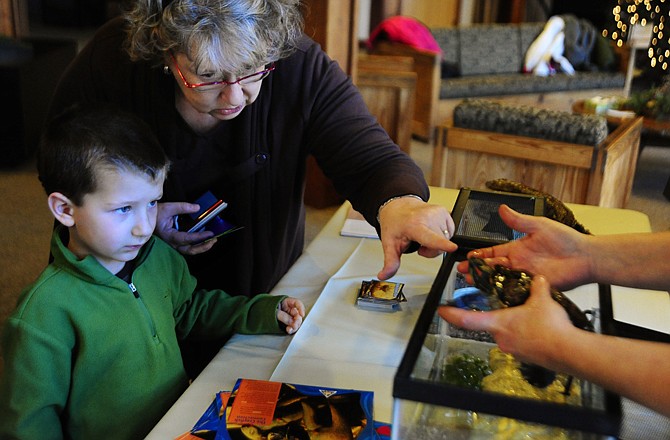 Assistant naturalist Kathy Widhaber holds a red-eared slider in 2011 as Nanci Beck, center, shows it to her grandson Noah Beck, 4, of Oklahoma City, Oklahoma, during Holiday Happenings at Runge Conservation Nature Center.