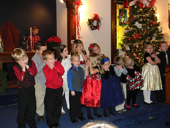 A group of children sing "Away in a Manger" during the Christmas Program.